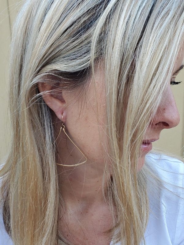 gold triangle earrings on model